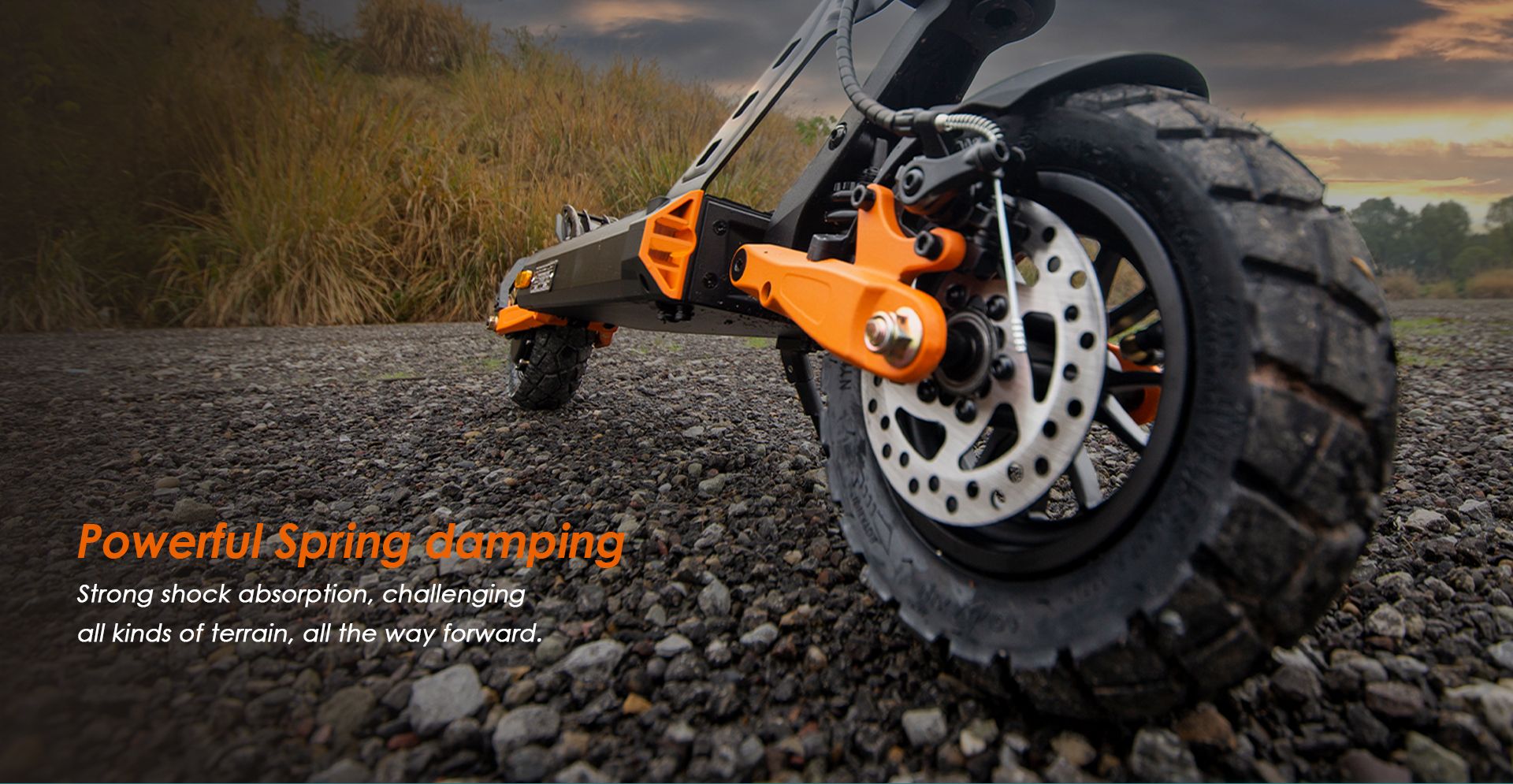 KuKirin G2 Pro ABE electric scooter close‑up view of spring damping suspension and off‑road tire on gravel terrain