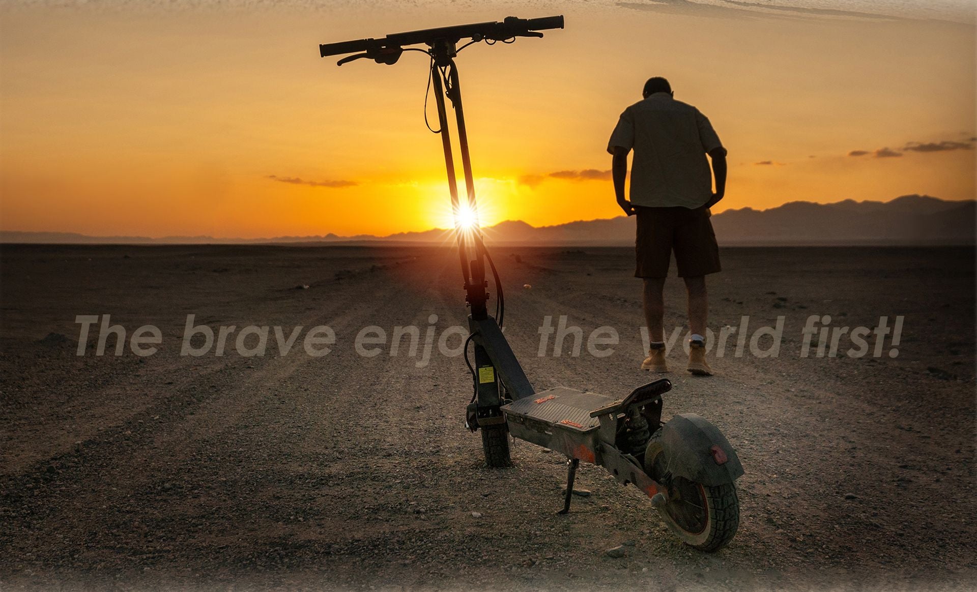 KuKirin G2 Ultra electric scooter parked on desert gravel road at golden sunset with a man standing nearby