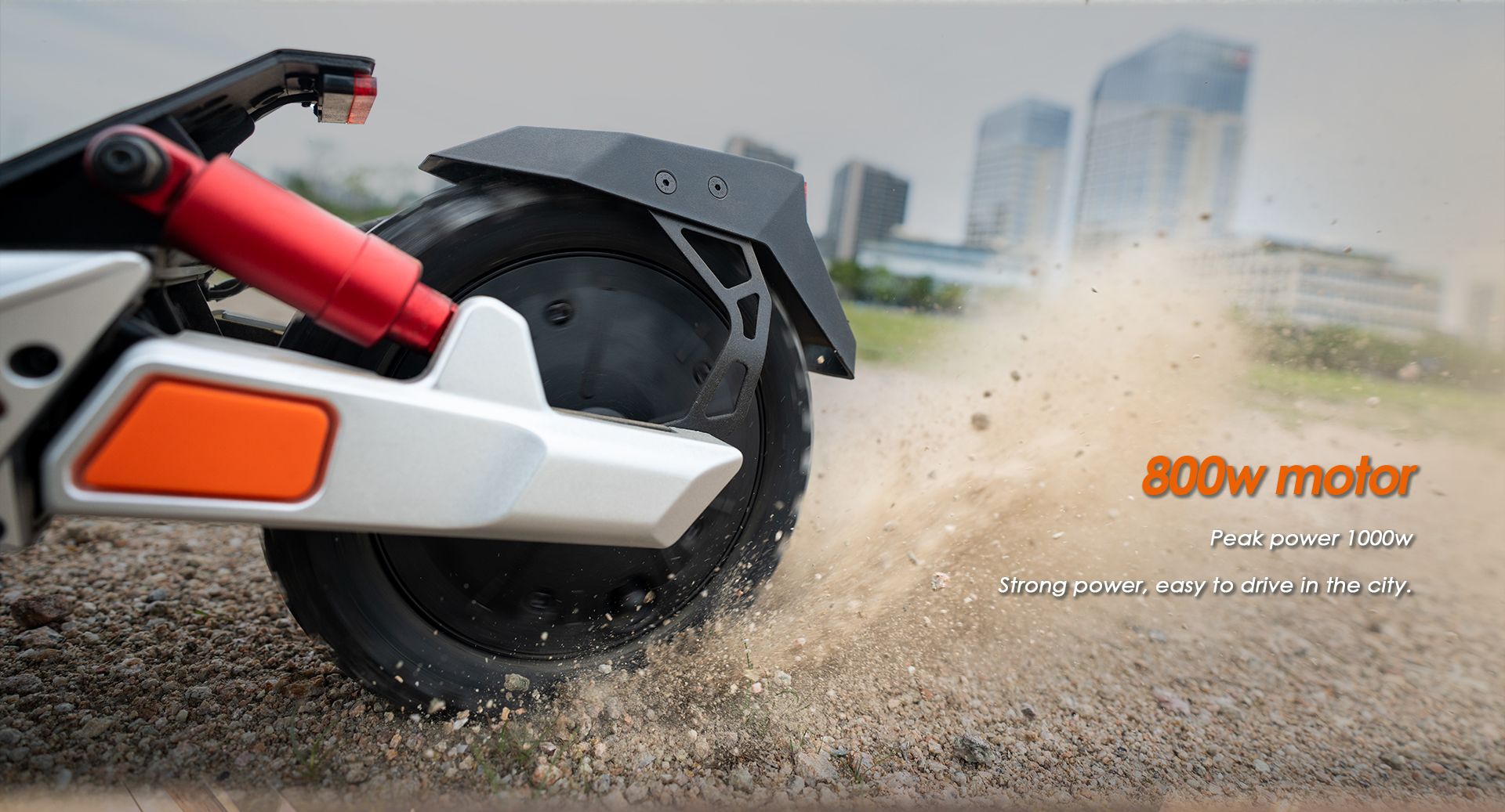 KuKirin M4 Max electric scooter rear wheel close‑up, 800W rated motor kicking up gravel for powerful off‑road performance