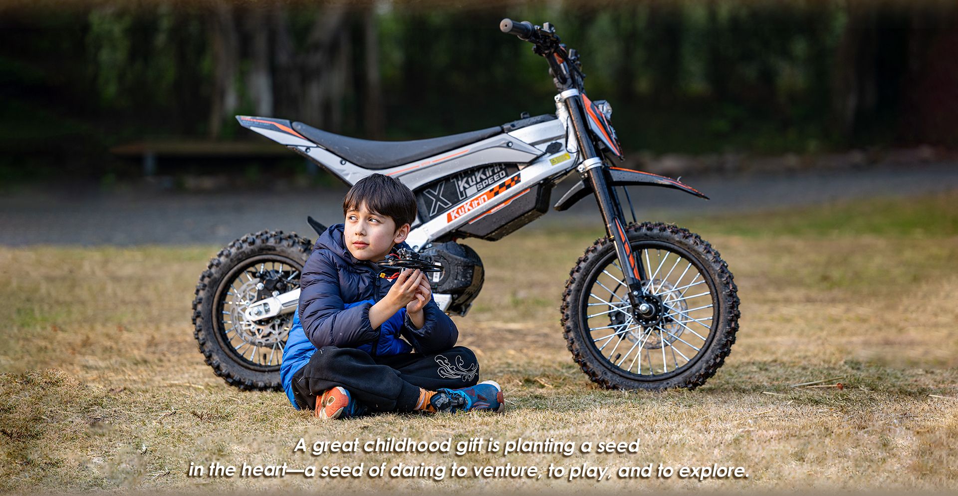 KuKirin X1 electric dirt bike parked on grass, ideal childhood gift for kids outdoor adventure exploration